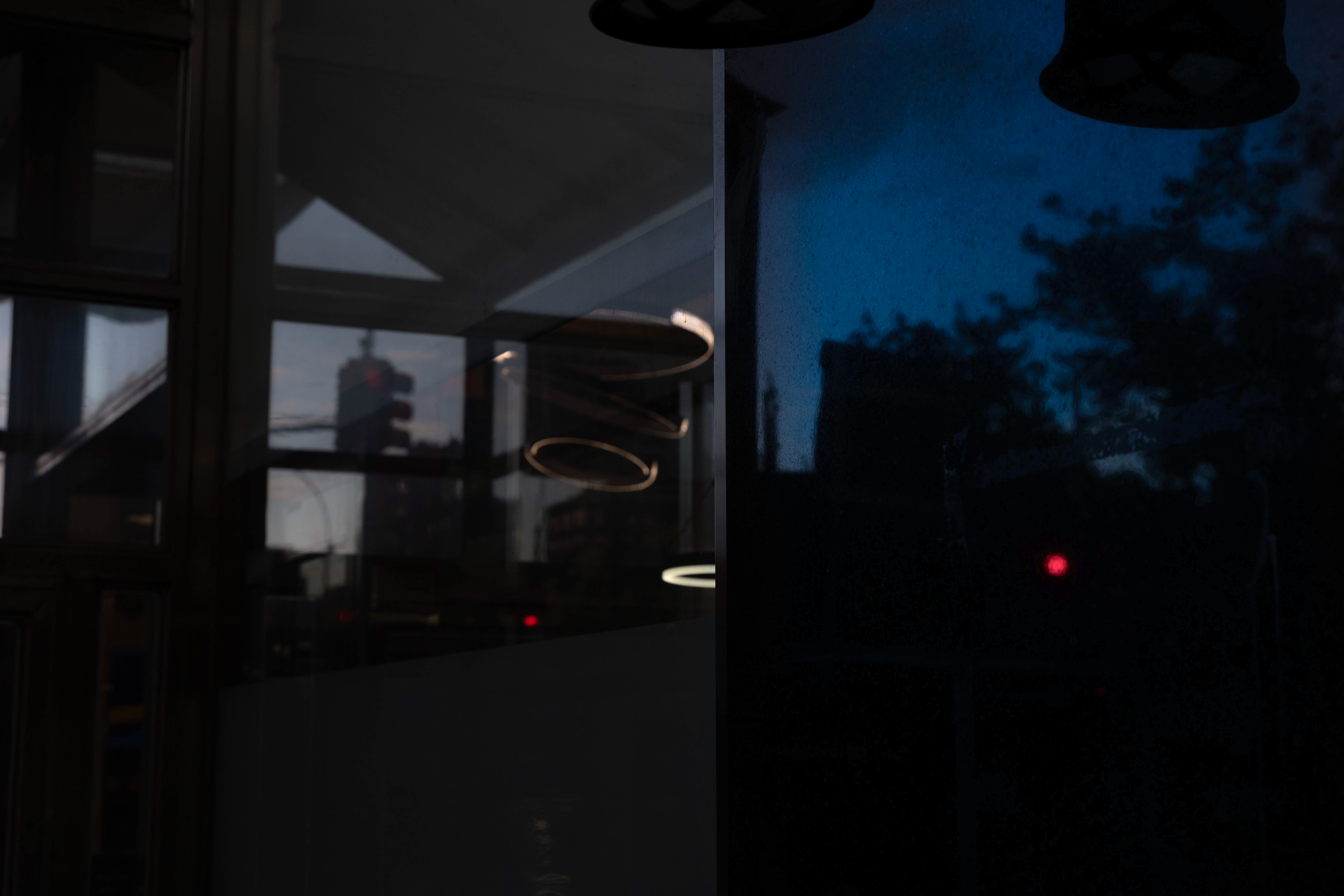 Tall glass building and parking sign under a dark stormy sky