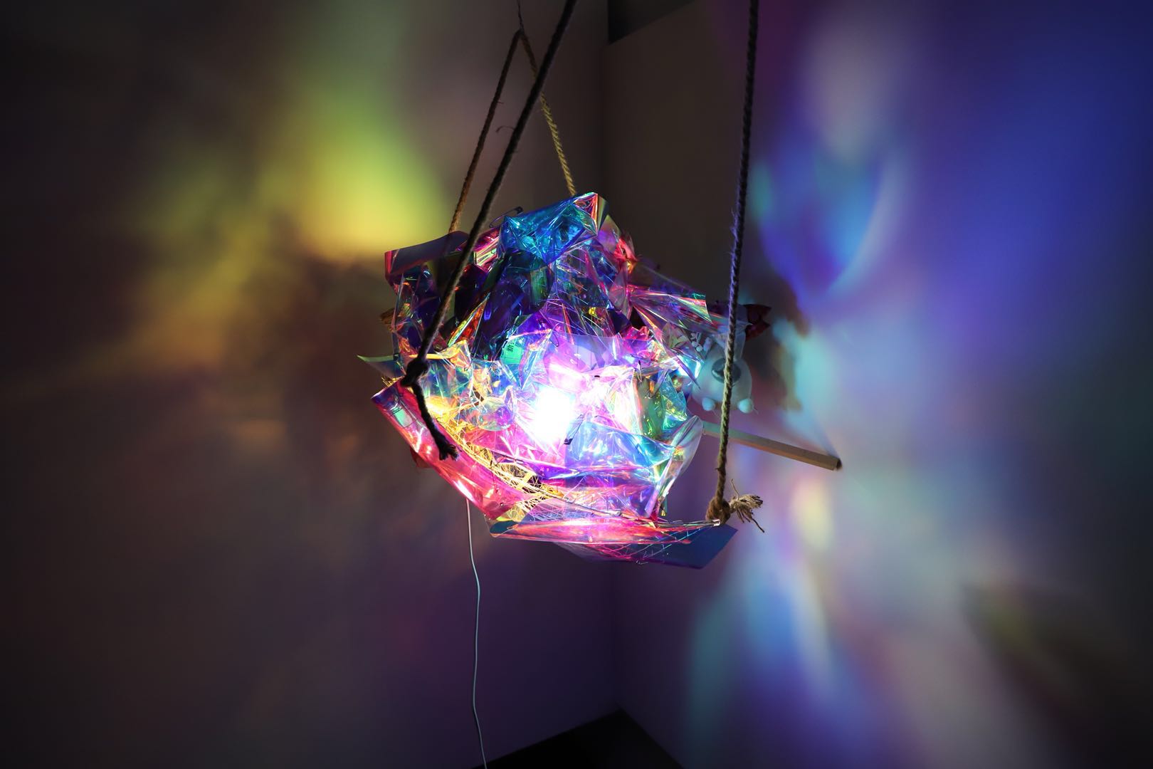 Detail view of the light sculpture showing translucent material, flowers, and colorful light